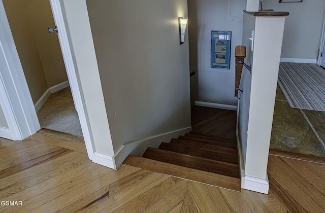 stairs featuring wood finished floors and baseboards