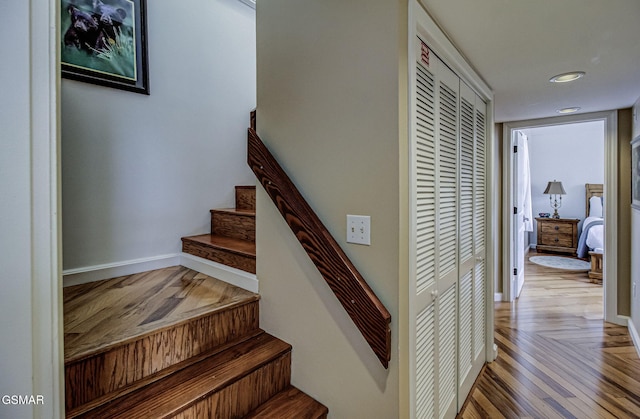 stairs with wood finished floors and baseboards