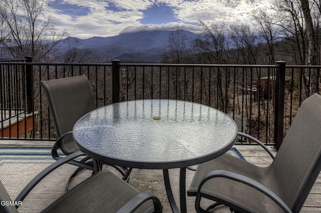 balcony with outdoor dining space and a mountain view