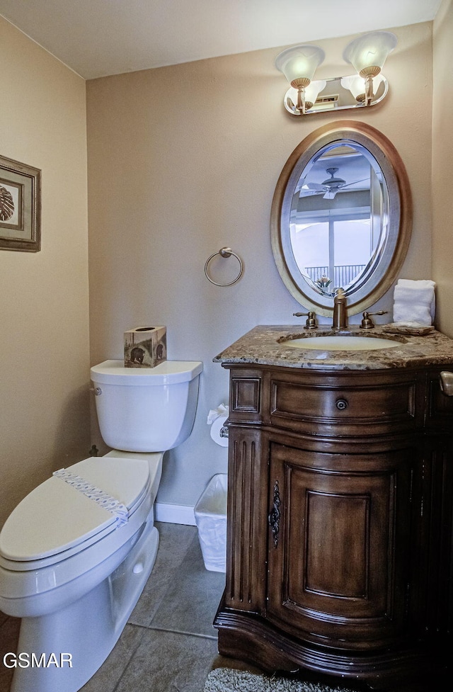 half bath with tile patterned flooring, vanity, baseboards, and toilet