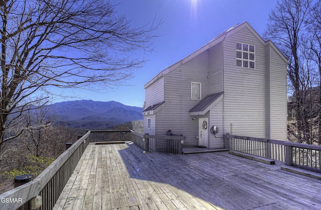 rear view of house with a deck with mountain view