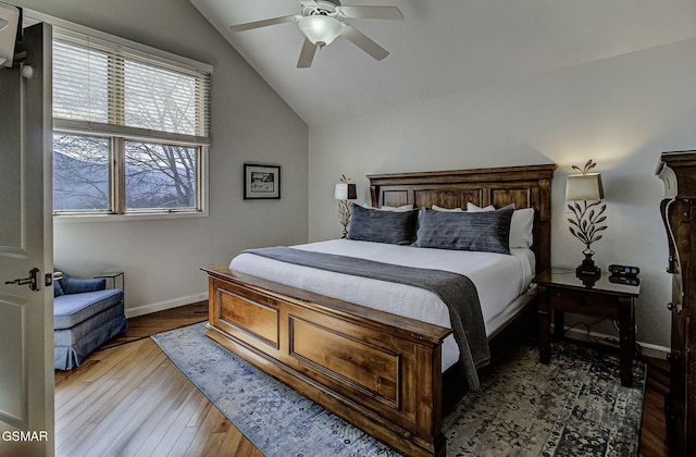 bedroom with wood finished floors, ceiling fan, baseboards, and vaulted ceiling