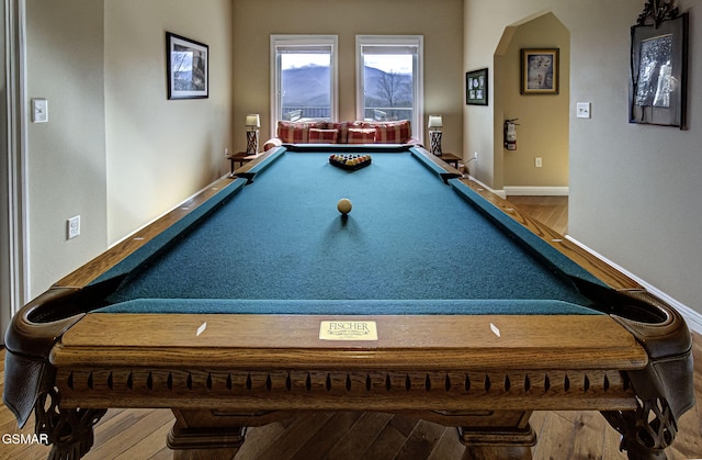 rec room featuring billiards, wood finished floors, arched walkways, and baseboards
