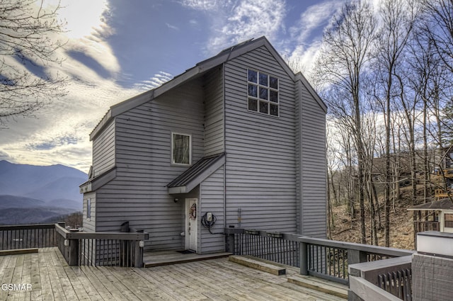 rear view of house featuring a deck with mountain view