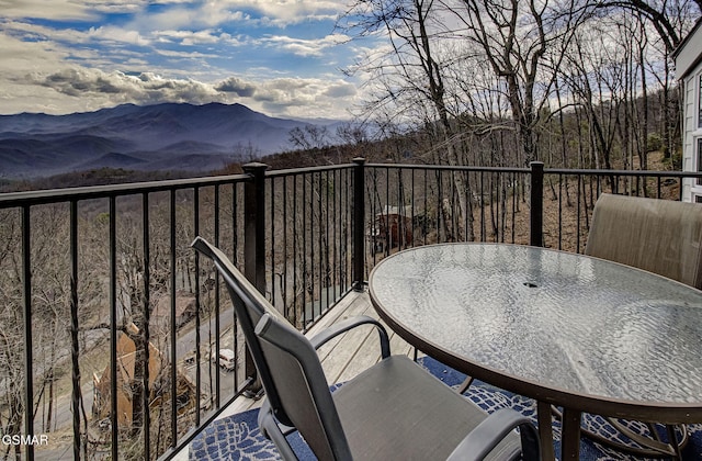 balcony with outdoor dining space and a mountain view