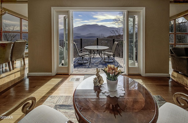 dining room with a mountain view, visible vents, baseboards, and hardwood / wood-style flooring