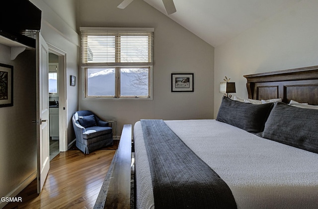 bedroom featuring ceiling fan, baseboards, lofted ceiling, and hardwood / wood-style flooring