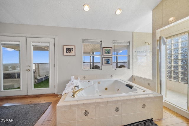 bathroom featuring hardwood / wood-style flooring, independent shower and bath, a textured ceiling, and french doors