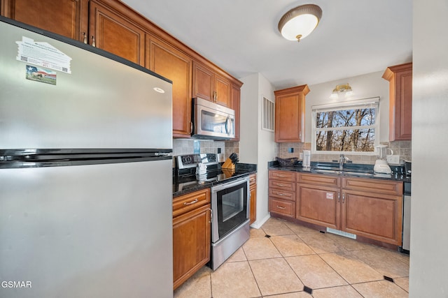 kitchen featuring stainless steel appliances, sink, light tile patterned floors, and decorative backsplash