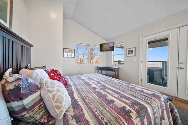 bedroom featuring french doors, wood-type flooring, vaulted ceiling, and a textured ceiling