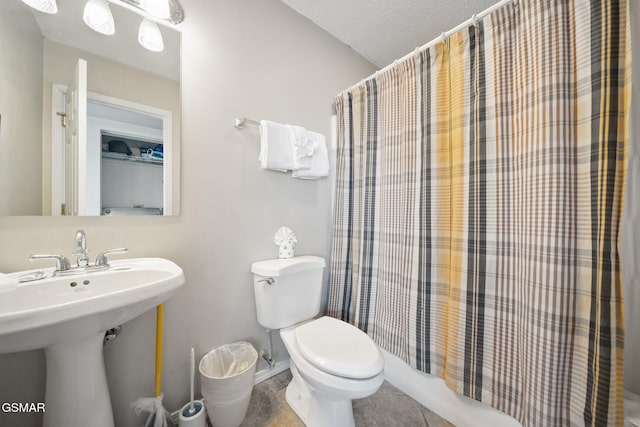 bathroom featuring tile patterned floors, toilet, sink, a shower with curtain, and a textured ceiling