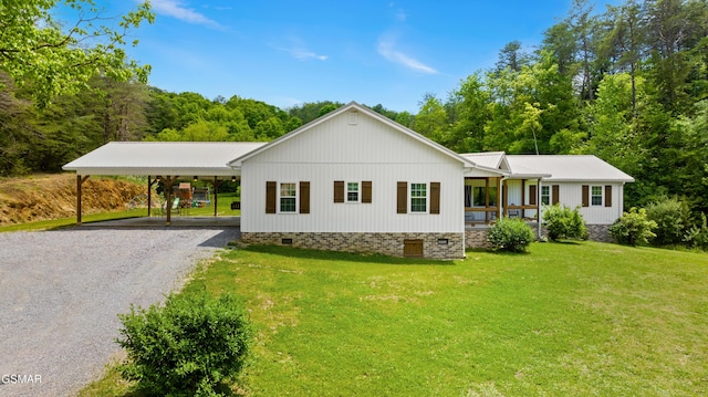 view of front facade featuring crawl space, driveway, a front yard, a carport, and covered porch