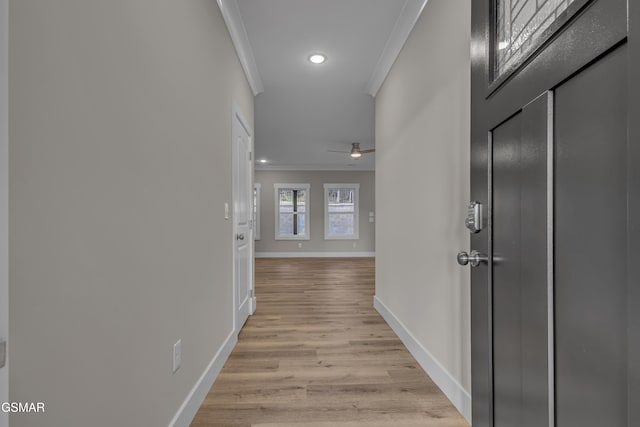 hall with light hardwood / wood-style floors and ornamental molding