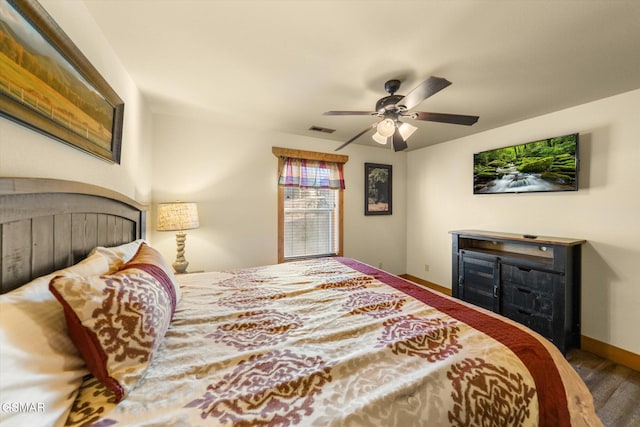 bedroom featuring ceiling fan, wood finished floors, visible vents, and baseboards