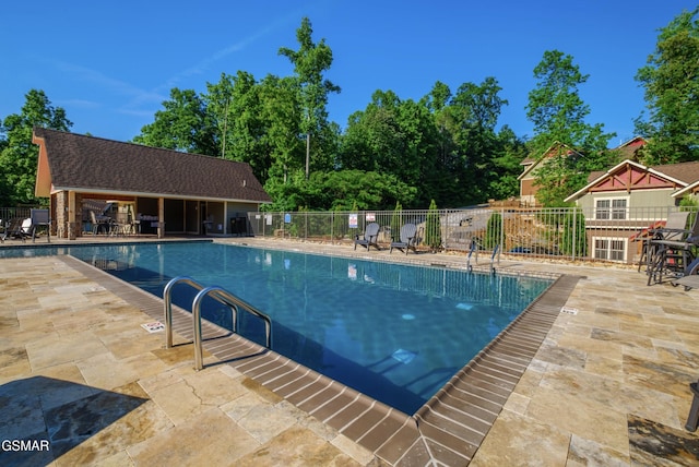 community pool with fence and a patio