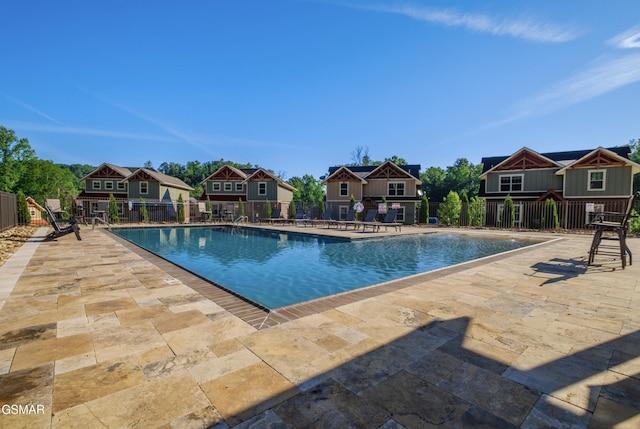 pool featuring fence and a patio