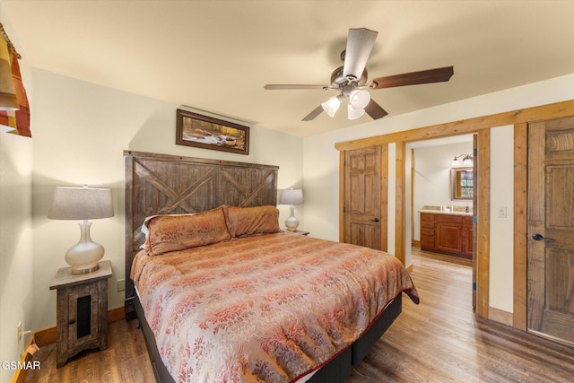 bedroom featuring ensuite bathroom, ceiling fan, wood finished floors, and baseboards