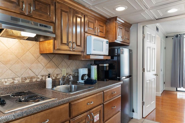 685 River Rd Unit 314, Gatlinburg, TN 37738 - kitchen with appliances with stainless steel finishes, under cabinet range hood, dark countertops, a sink, and decorative backsplash