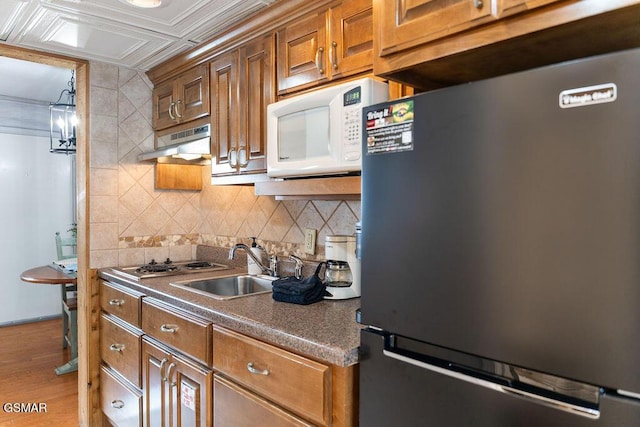 685 River Rd Unit 314, Gatlinburg, TN 37738 - kitchen featuring stainless steel appliances, under cabinet range hood, tasteful backsplash, and brown cabinetry