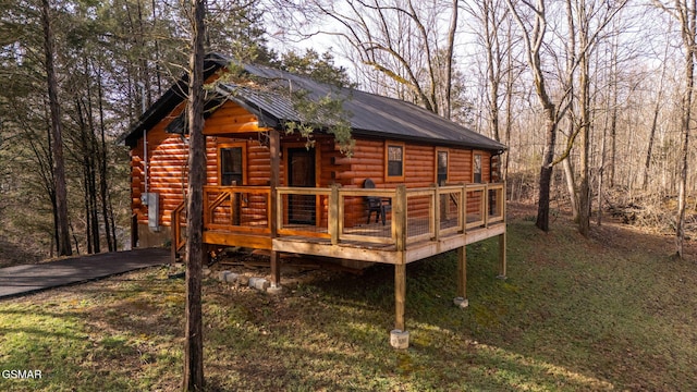 rear view of house with metal roof, a wooden deck, and log exterior