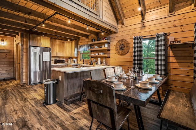 dining room with wood walls, wooden ceiling, track lighting, dark hardwood / wood-style floors, and beam ceiling