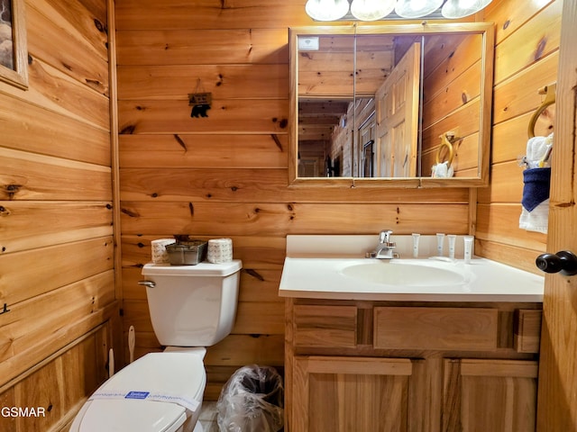 half bath featuring vanity, toilet, and wood walls