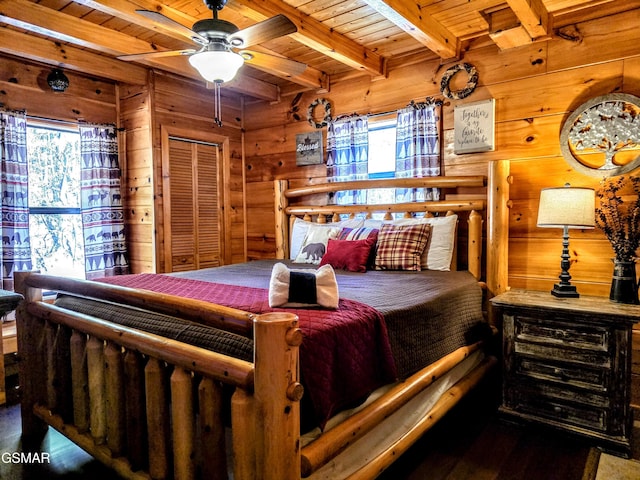 bedroom with beam ceiling, wooden walls, and wood ceiling