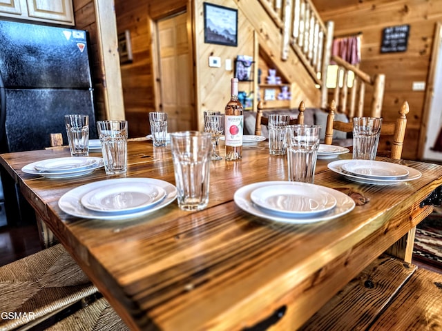 dining area featuring stairway and wood walls