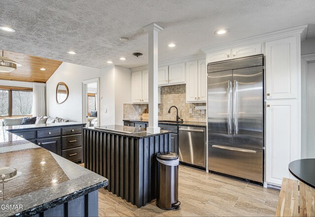 1130 Ski View Dr Unit 315, Gatlinburg, TN 37738 - kitchen with stainless steel appliances, a kitchen island, white cabinets, decorative backsplash, and recessed lighting