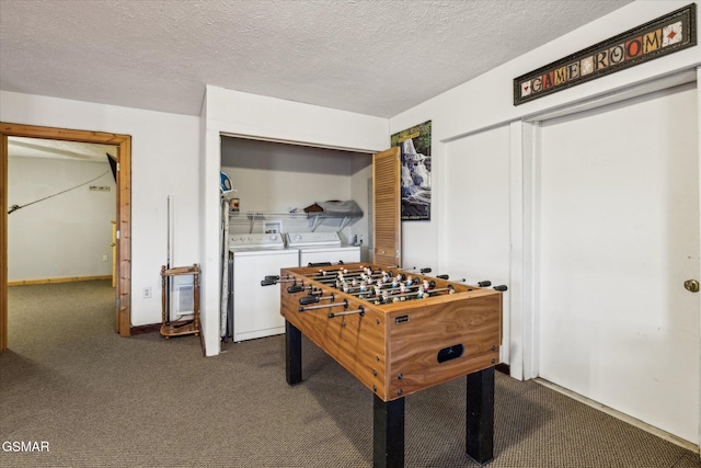 rec room featuring a textured ceiling, dark carpet, and washer and dryer