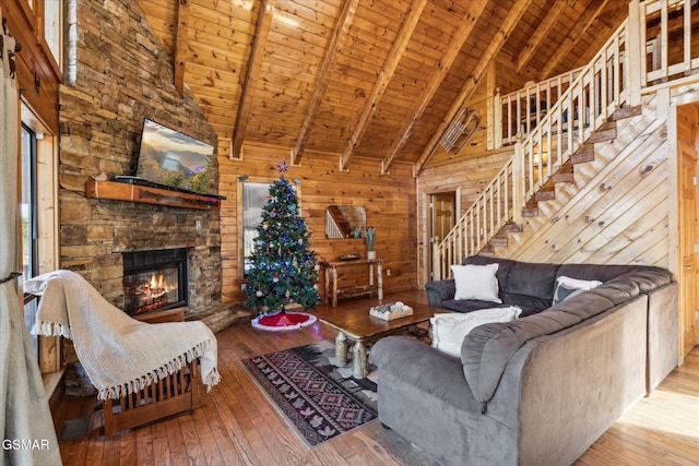 living room with a fireplace, wooden walls, wooden ceiling, beamed ceiling, and hardwood / wood-style flooring