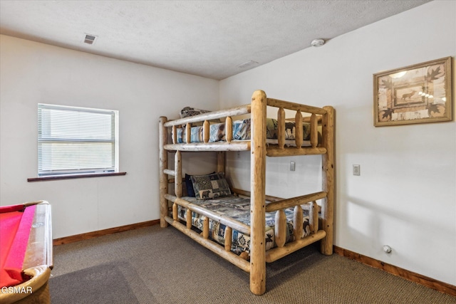 carpeted bedroom with visible vents, a textured ceiling, and baseboards