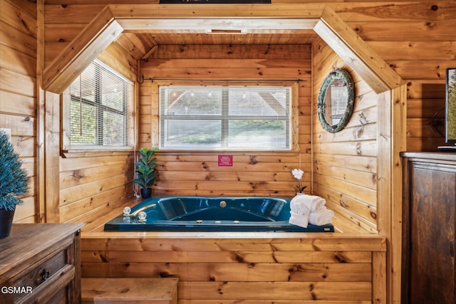 bathroom featuring wood walls and a jetted tub