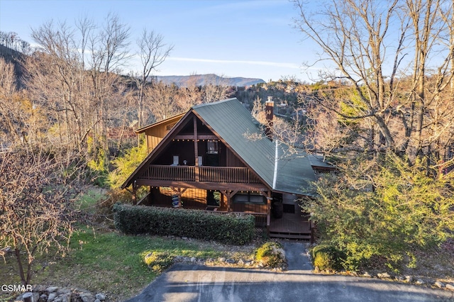 view of front of house featuring metal roof, a wooded view, and a mountain view