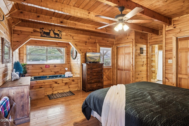 bedroom with wood walls, beamed ceiling, and wooden ceiling