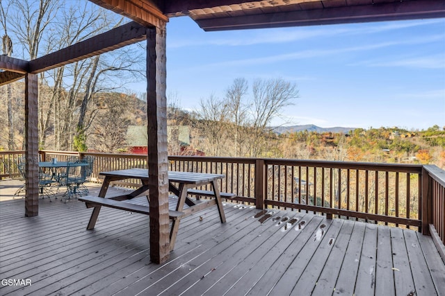 wooden terrace featuring outdoor dining space and a mountain view