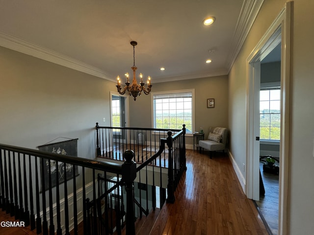 hall featuring dark wood-style floors, crown molding, an upstairs landing, a chandelier, and baseboards