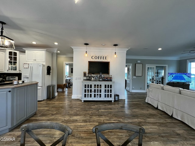 living area with baseboards, ornamental molding, dark wood-style flooring, and recessed lighting