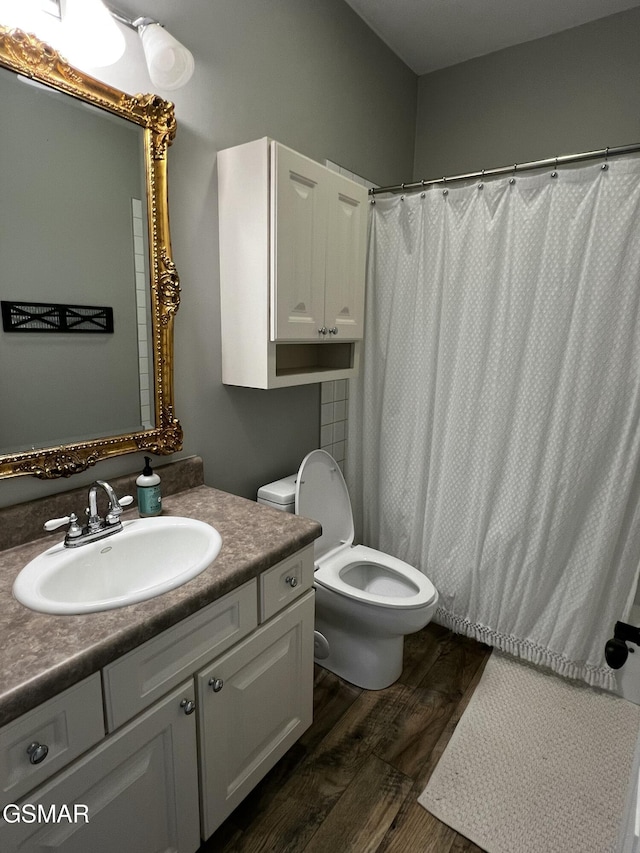 bathroom with vanity, wood finished floors, and toilet