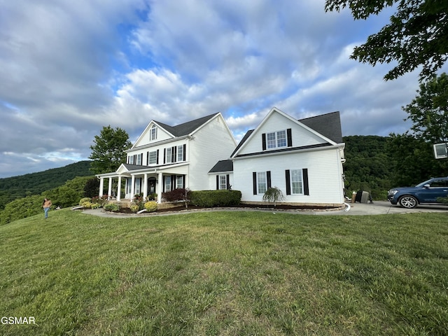 view of front of house with covered porch and a front lawn