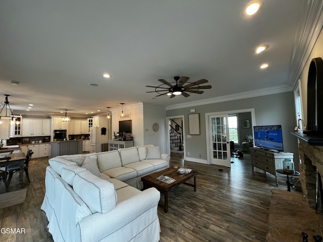 living area featuring stairway, recessed lighting, dark wood finished floors, and crown molding