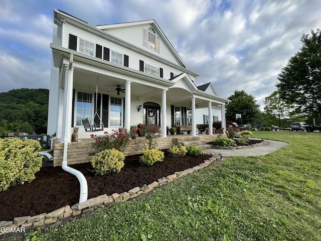 view of front of house featuring a porch, a front yard, and a ceiling fan