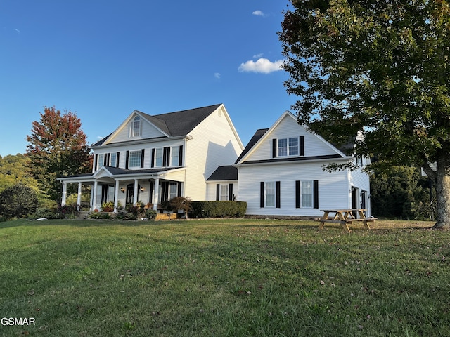 view of front of home with covered porch and a front yard