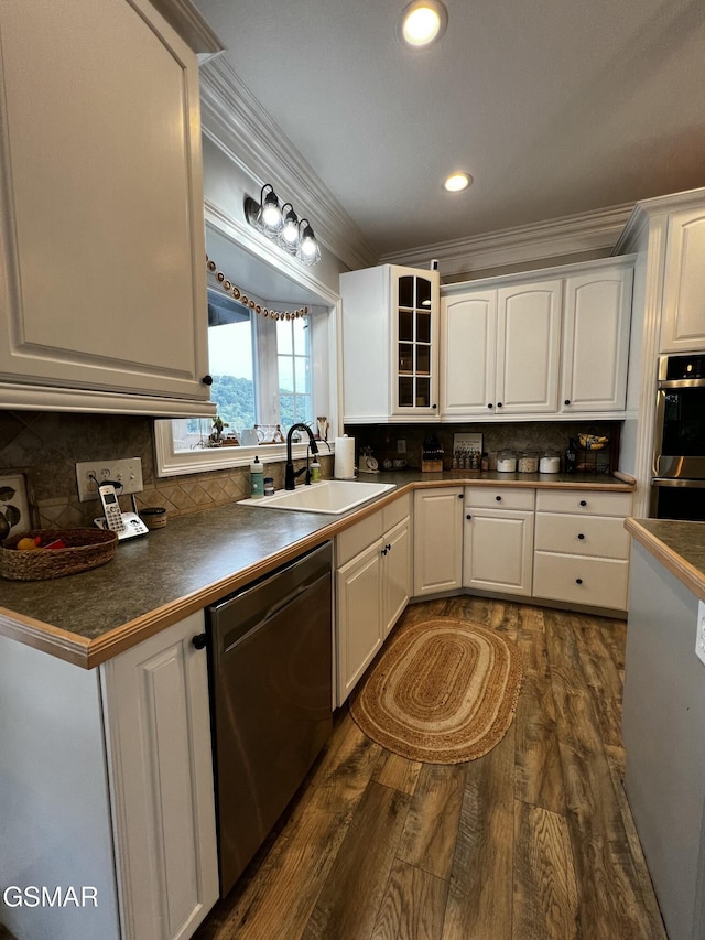 kitchen featuring dishwashing machine, a sink, white cabinets, dark countertops, and glass insert cabinets