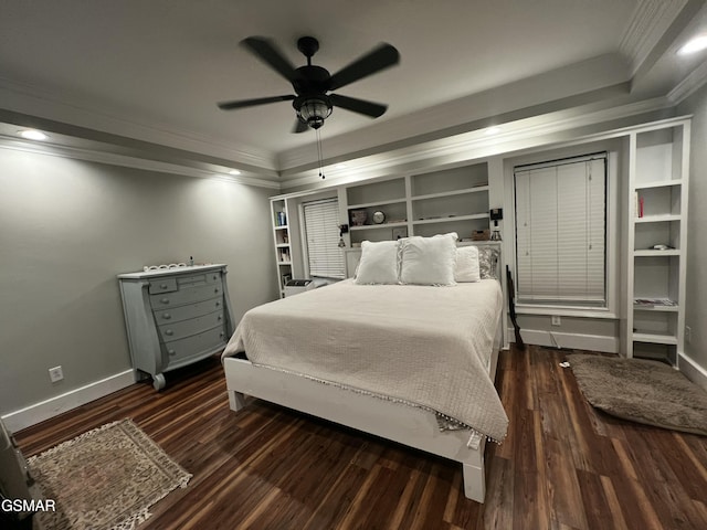 bedroom featuring ornamental molding, a tray ceiling, dark wood finished floors, and baseboards