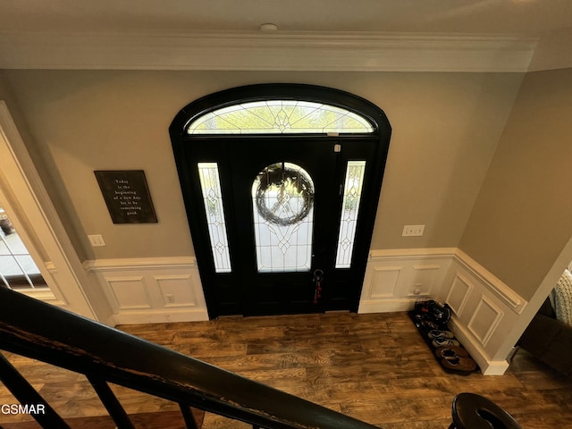 entrance foyer with dark wood-style floors, a wainscoted wall, and a decorative wall