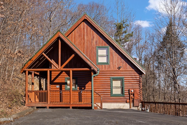 log cabin featuring covered porch