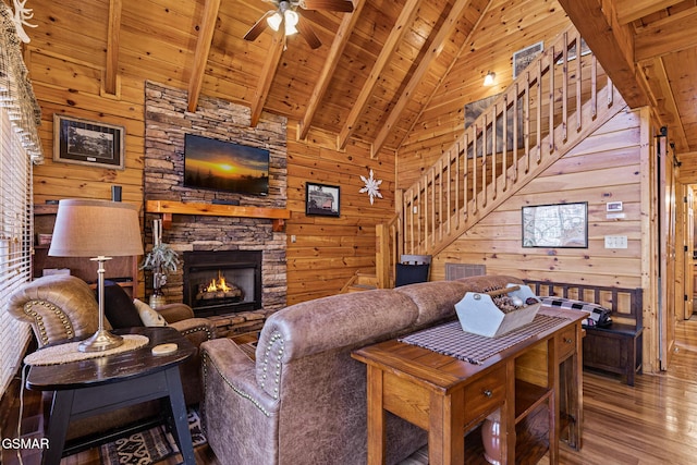 living room featuring beam ceiling, wood ceiling, wood-type flooring, wooden walls, and a fireplace