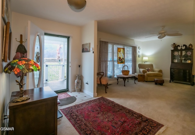 carpeted entrance foyer featuring ceiling fan and baseboards