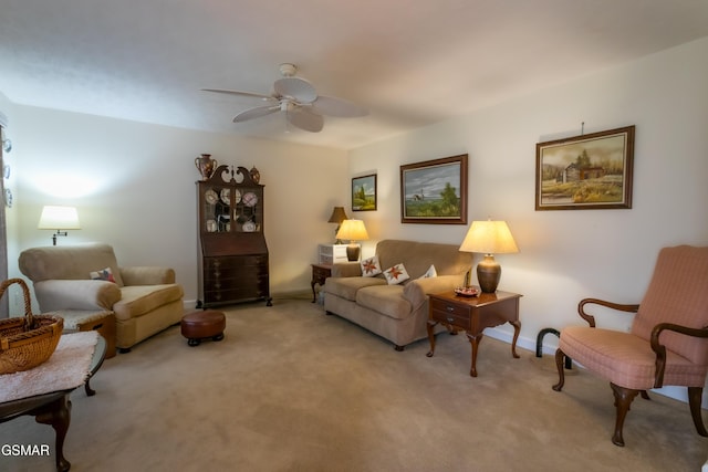 living area featuring light carpet, baseboards, and a ceiling fan